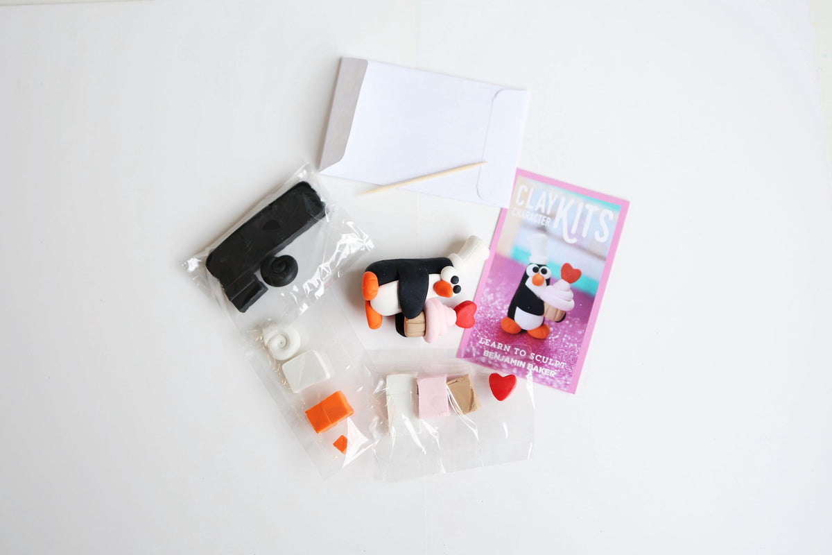 Penguin-themed craft kit with supplies on a white background