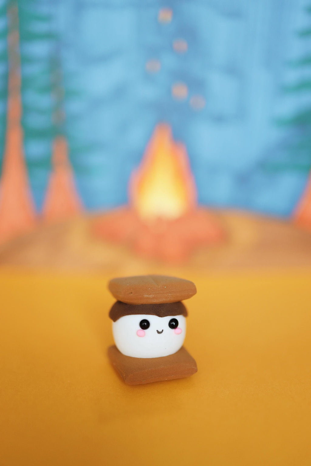 Cute s'more marshmallow character with a campfire and trees in the background