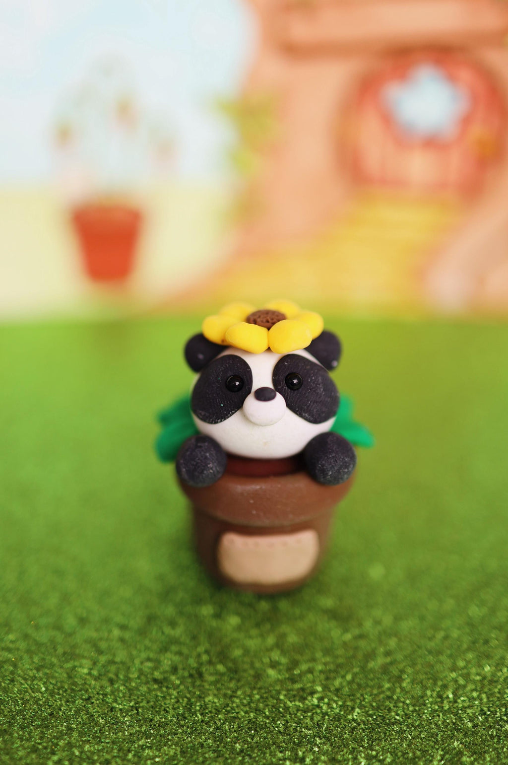 Panda figurine with a flower on a grassy background