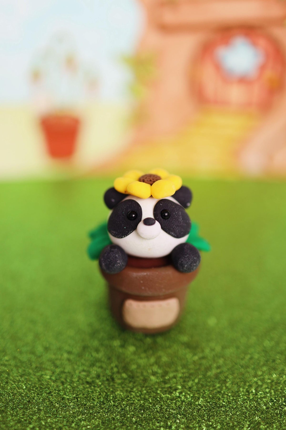 Panda figurine with a flower on a grassy background