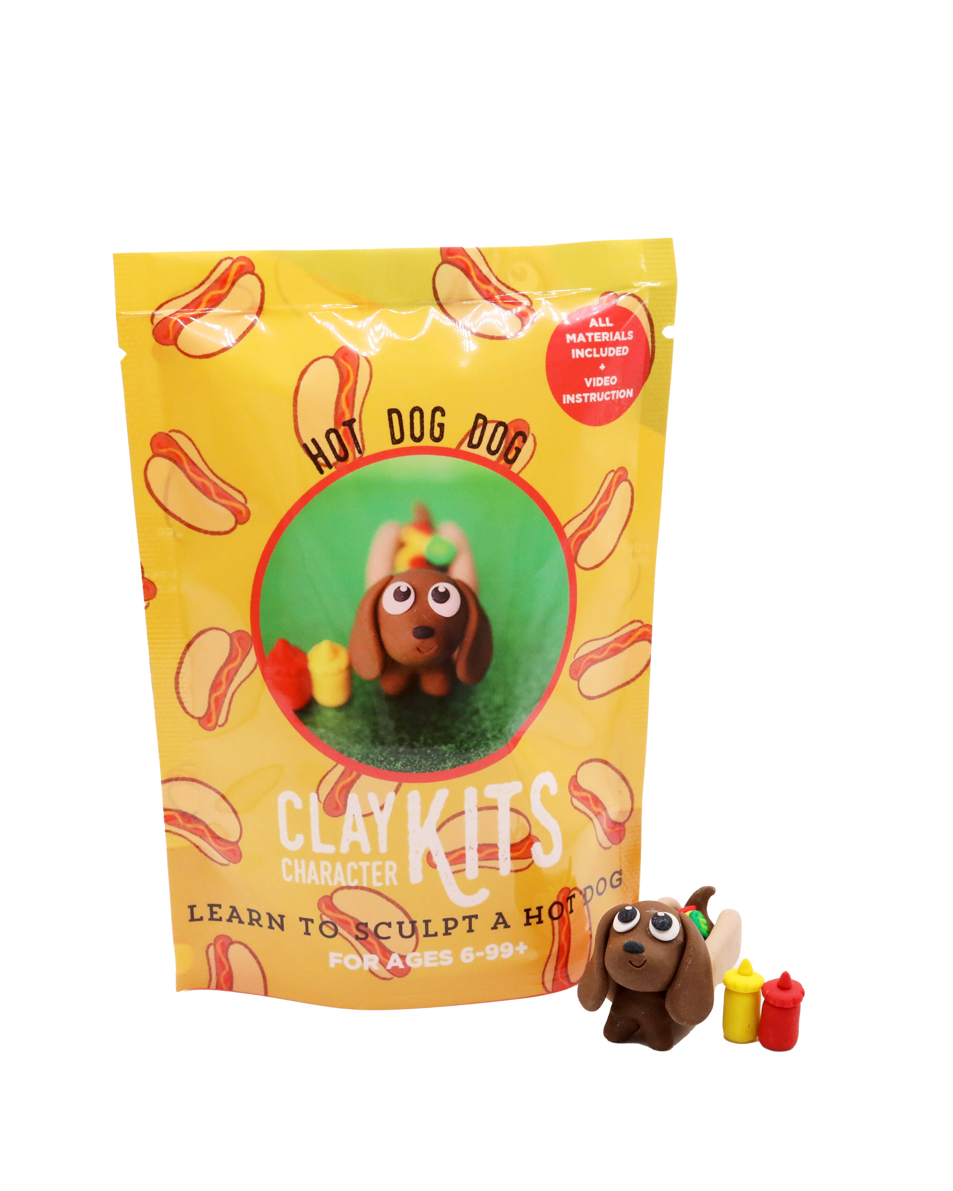 Yellow packaging of Hot Dog Dog Clay Kids with a small clay dog figure in front on a white background