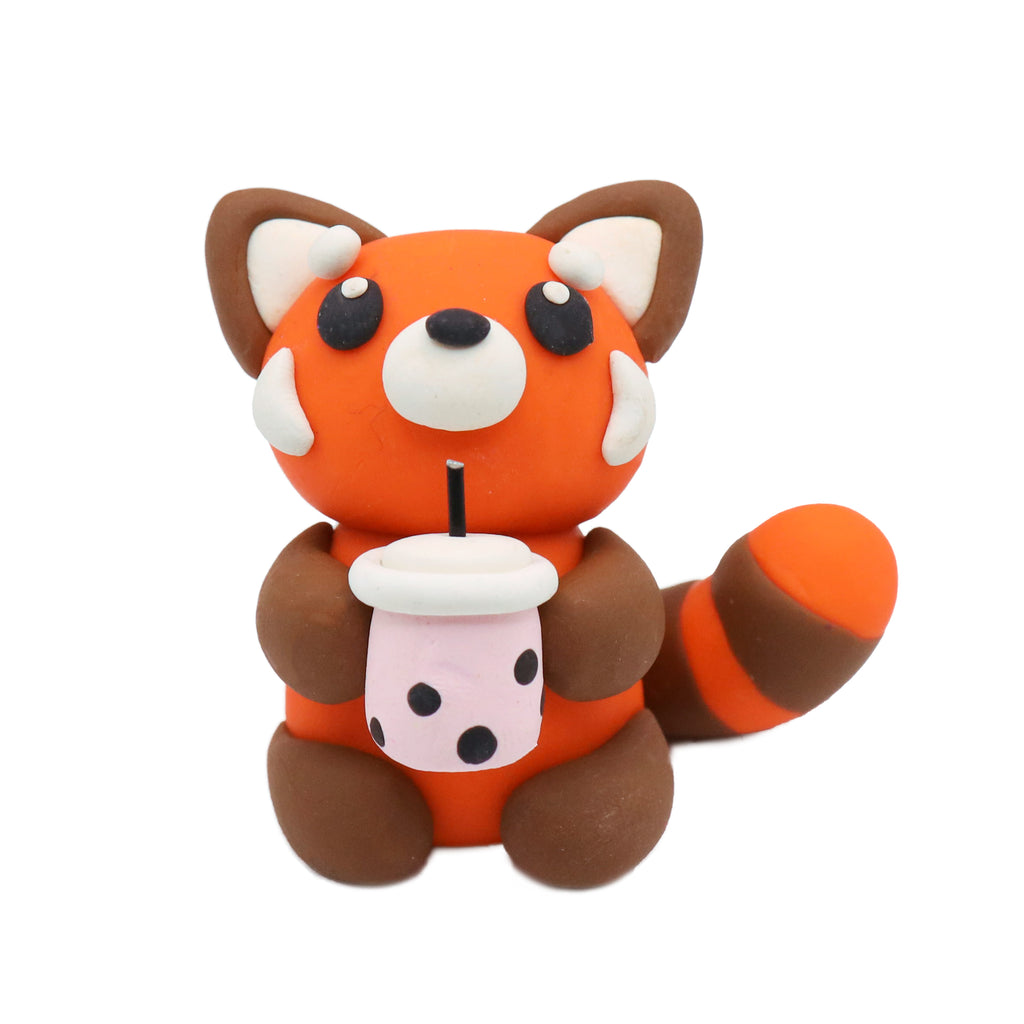polymer clay red panda holding a boba cup on a white background